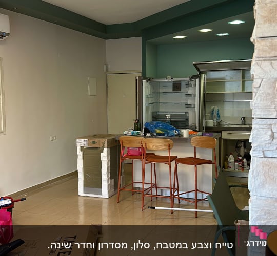 פחיות צבע אדומות על הרצפה ליד קופסאות קרטון
